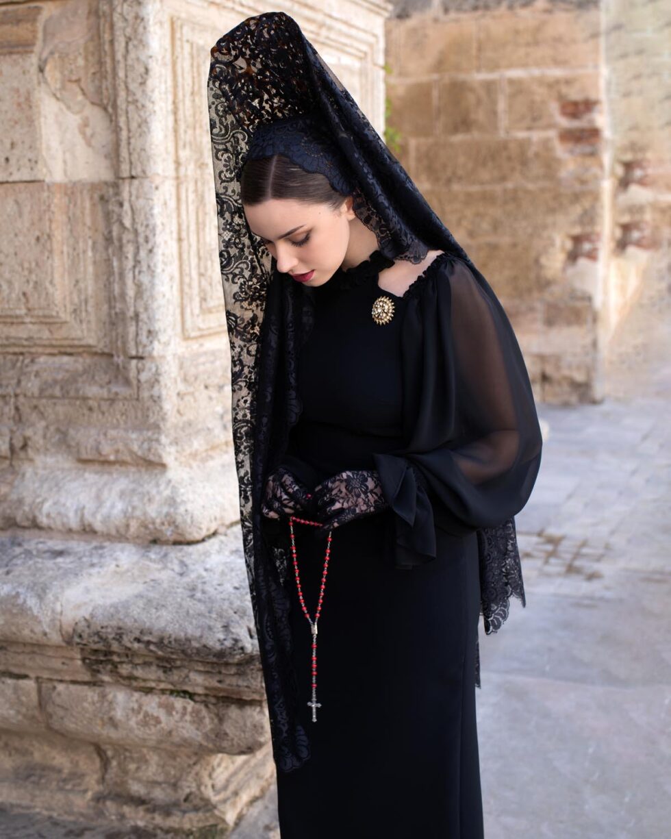 Vestido Noelia midi entallado en crepé elástico negro con mangas largas de gasa y puños elásticos, diseño refinado para actos de Semana Santa